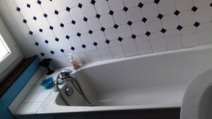 A bathroom with a white bathtub, a blue basin, and a white sink. - Chambre mauresque la maison de josepha (Ferrals-les-Corbières)