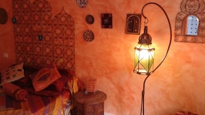 A room with a patterned wall, a lantern, and a small table with a bottle. - Chambre mauresque la maison de josepha (Ferrals-les-Corbières)