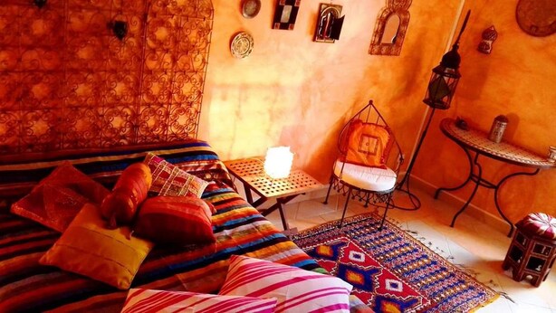 A cozy room with a bed, a chair, a small table, and a patterned rug. - Chambre mauresque la maison de josepha (Ferrals-les-Corbières)