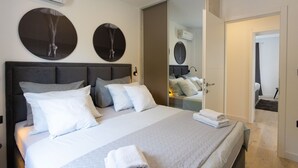 A modern hotel room with a large bed, a headboard, and two wall-mounted mirrors. - Villa Marko (Makarska)