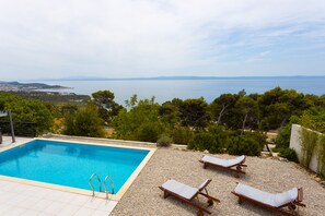 季节性开放的室外游泳池，池畔遮阳伞，日光浴躺椅