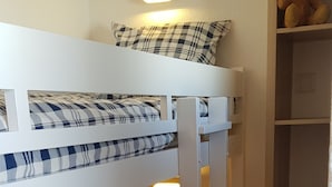 A bunk bed with a checkered bedspread, a black pillow, and a shelf with a teddy bear. - Studio 4 P amazing vue (Avoriaz)
