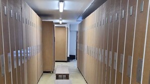 A corridor with lockers on both sides, a wooden bench in the center, and a door at the end. - Studio 4 P amazing vue (Avoriaz)