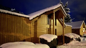 A wooden cabin with snow-covered roofs and steps, surrounded by snow. - Chalet Capucine 1 in the heart of the Vosges mountains (Gérardmer)