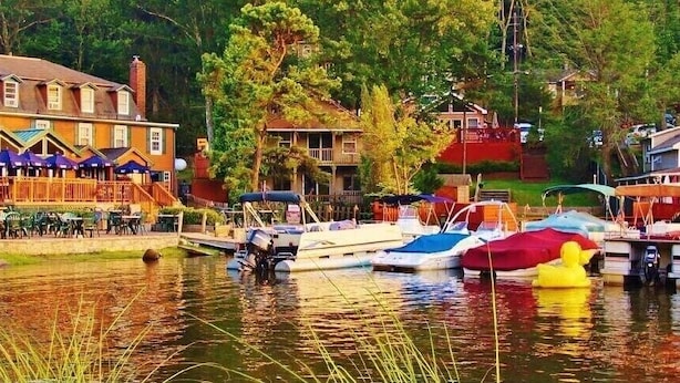 Un hôtel situé au bord du lac, doté d’une terrasse et de bateaux amarrés.
