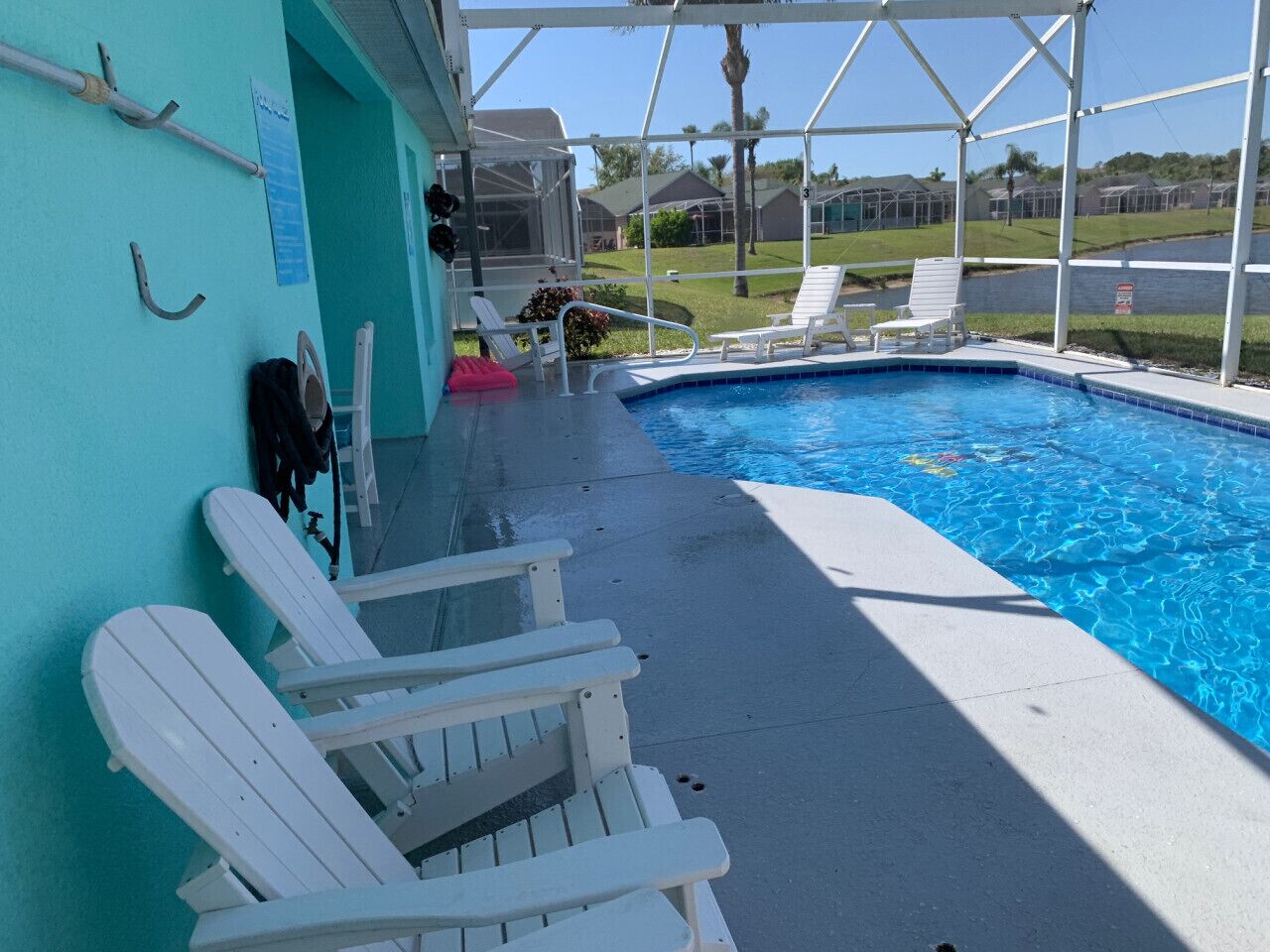Un espace piscine doté de chaises longues blanches et offrant une vue dégagée sur le paysage environnant.