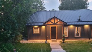A two-story house with a dark metal roof and wooden siding. - Fully renovated luxury waterfront cottage (Havelock)