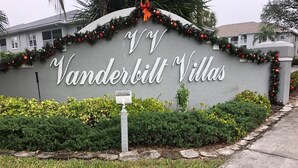 A sign for Vanderbilt Villas with a decorative garland and a mailbox. - Vanderbilt Beach less than a mile! Dog friendly, Tropical Paradise! 3br & WiFi! (Naples)