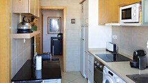A compact kitchen with a microwave, toaster, and washing machine. - Cabanas Gardens,  6px, terrace and barbecue (Cabanas de tavira)