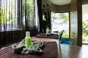 Une salle de spa équipée d’une table de massage, de serviettes et de bougies.