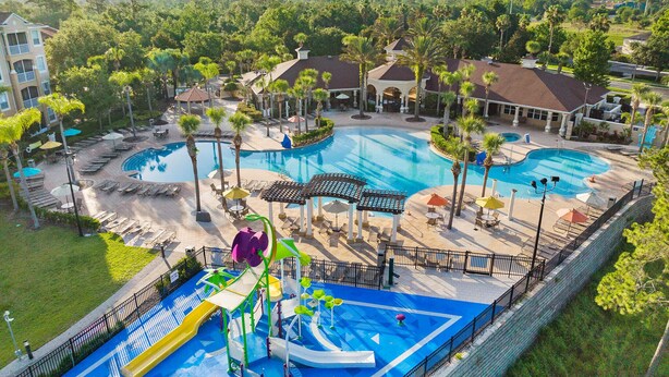 A resort with multiple swimming pools, a water park, and lounge areas surrounded by palm trees. - Windsor Hills Home w/ Pool 2 miles from Disney! (Kissimmee)