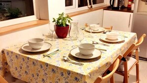 A dining table set with plates, bowls, cutlery, and a potted plant. - Entire House in Canterbury Centre - Free Parking - WiFi (Canterbury)