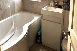 Tina con regadera, toallas, jabón, papel de baño 