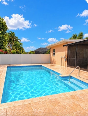 A rectangular swimming pool with clear blue water, surrounded by a tiled deck. - Walk to Beach 2- Patios Updated Lux Retreat NEW Heated Pool Sleeps 10 Small Dogs (Naples)