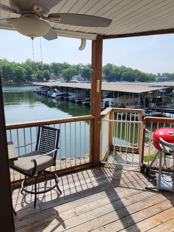 Enjoy a serene view of the marina from this outdoor deck, featuring a grill and comfortable seating.