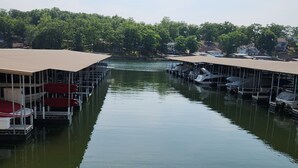 A marina with docks and boats, surrounded by trees and houses. - 2 bed King Master/2 bath condo with lake access and large 16 x 40 boat slip (Osage Beach)