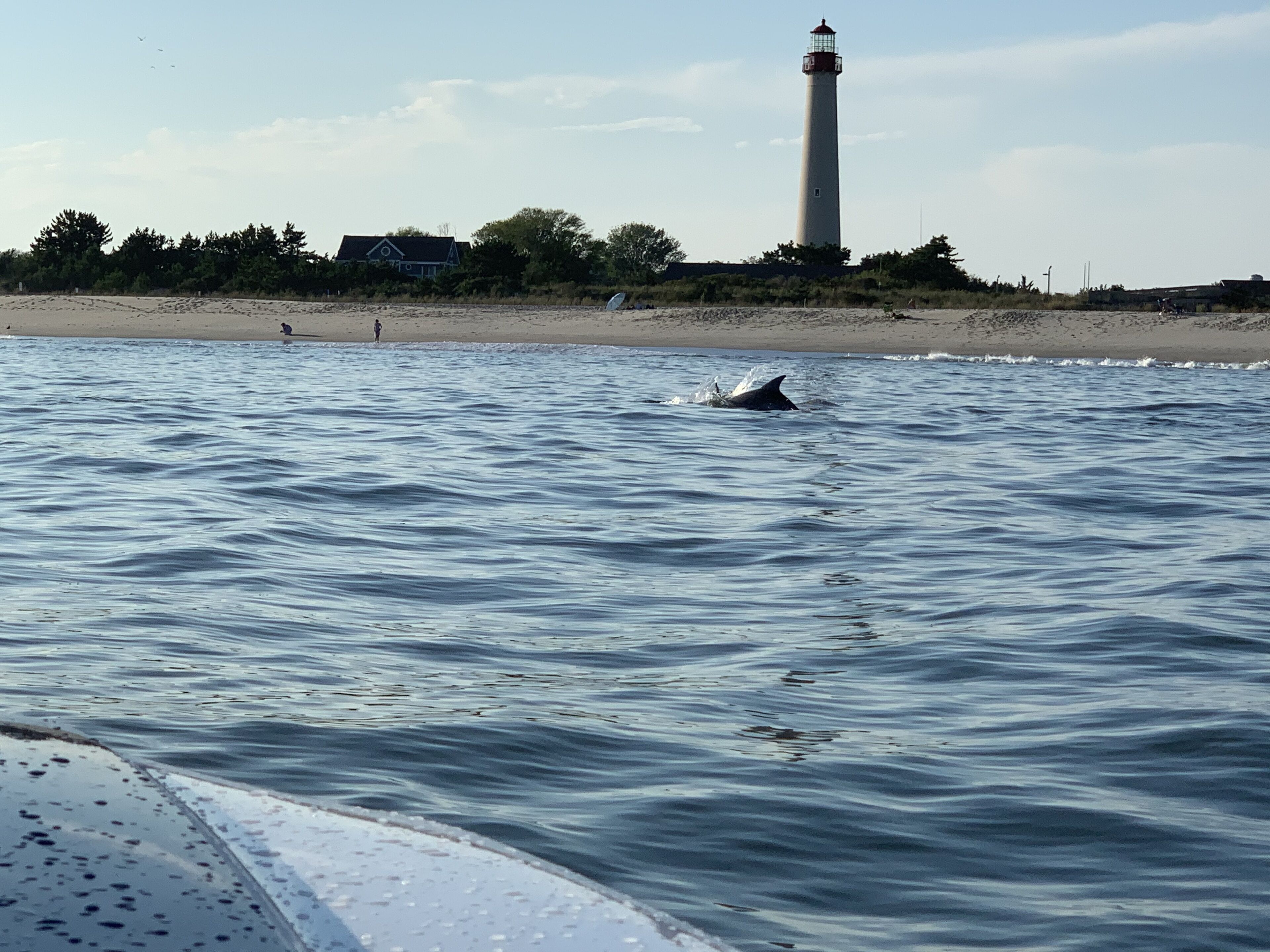 Un phare sur une plage, avec une eau calme.
