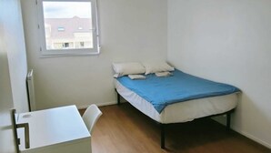 A small, single-bed room with a window, a desk, and a chair. - Comfortable room near Paris and transport (Achères)