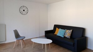 A modern living room with a black sofa, a grey chair, and a white coffee table. - Comfortable room near Paris and transport (Achères)