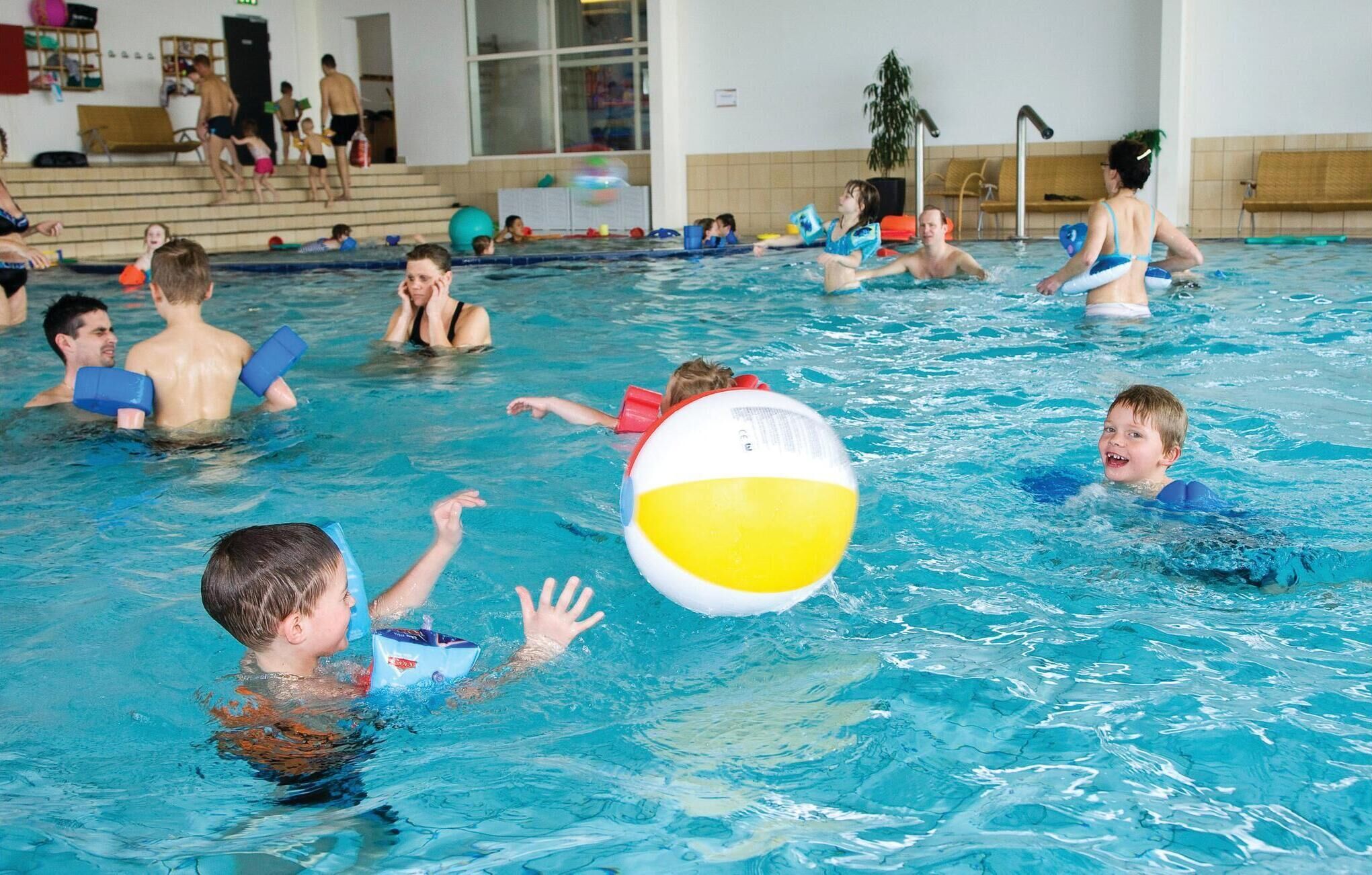 A swimming pool with people engaged in water activities.