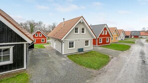 A row of traditional houses with red and white exteriors, a gravel driveway, and a clear sky. - 4 bedroom awesome home in Gråsten (Gråsten)