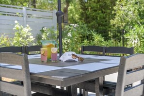 A table with a glass of orange juice, a glass of pink drink, and a white cap with sunglasses on it. - Luxury 8BR Home w/ Pickleball, Pool & Spa (Santa Rosa Beach)