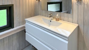 A bathroom with a white sink, a mirror, and wooden paneling on the walls. - 3 bedroom gorgeous home in Væggerløse (Væggerløse)