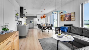 Un espacio moderno con comedor, cocina y sofá con vistas.