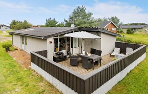 Enjoy outdoor meals and gatherings in the enclosed patio area with a dining table and chairs.