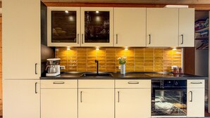 A kitchen with cabinets, a coffee maker, a sink, and a dishwasher.