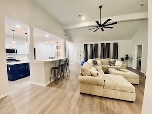 Relax in this open-plan living space with a kitchen, comfortable sofa, and stylish coffee table.