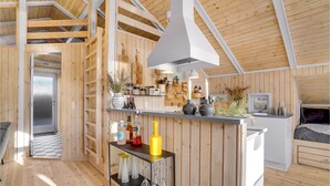 A compact, wooden interior with a kitchen area, a dining space, and a sleeping area. - Awesome home in Juelsminde with WiFi (Juelsminde)