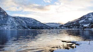 A serene lake surrounded by snow-covered mountains.