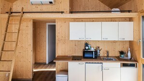 Una cucina compatta con mobili in legno, un lavello e un piccolo frigorifero.