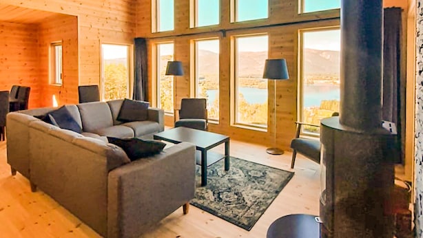 A cozy living room with a sofa, coffee table, and chairs, large windows with a view, and a fireplace. - Beautiful home in Vrådal with sauna (Vrådal)