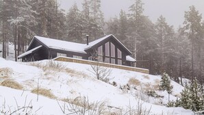 A cabin with a sloped roof, large windows, and a wooden deck. - Beautiful home in Vrådal with sauna (Vrådal)