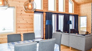 A cozy cabin interior with a dining area, sofa, and large windows. - Beautiful home in Vrådal with sauna (Vrådal)