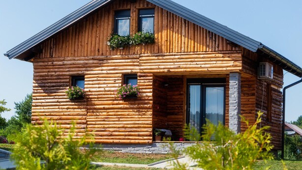 A log cabin with a sloped roof, large windows, and a stone foundation. - Stunning home in Slunj with swimming pool (Slunj)