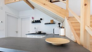 A modern kitchen with a dark countertop, wooden beams, and a bowl on the counter. - Stunning home in Slunj with swimming pool (Slunj)