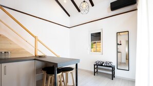 A modern kitchen with a wooden staircase, a dining area with stools, and a view of the outside through a window. - Stunning home in Slunj with swimming pool (Slunj)