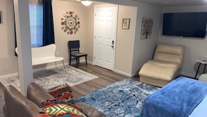 A living room with a sofa, a chair, a blue rug, and a beige armchair. - Lovely Lovelock Landing (Lovelock)