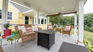 A covered porch with wicker furniture, a black table, and a sign indicating 'Lake House'. - Lake Winnipesaukee, Weirs Beach, Funspot, Gunstock (Laconia)