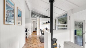 A modern interior with a central fireplace, white walls, and a tiled floor.