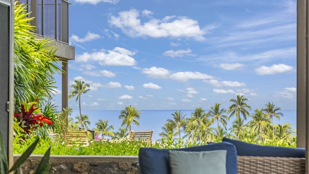 A balcony with wicker furniture and a view of the ocean and palm trees. - Stunning 2-bedroom Wailea Elua, walk to beach, ocean view!  (Kihei)