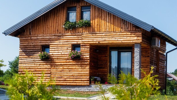 A log cabin with a sloped roof, large windows, and flower boxes on the front. - Nice home in Slunj with swimming pool (Slunj)