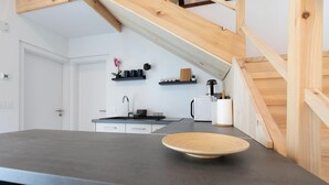 A modern kitchen with a dark countertop, white cabinets, and a wooden ceiling beam. - Nice home in Slunj with swimming pool (Slunj)