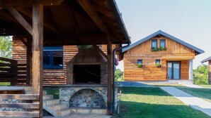 A rustic cabin with a stone fireplace, wooden exterior, and a covered porch. - Nice home in Slunj with swimming pool (Slunj)