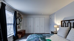 A bedroom with a bed, a nightstand, a lamp, a dresser, and a window with curtains. - Webster Groves detached Mother-in-Law Suite (Webster Groves)