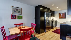 A modern kitchen with a wooden dining table and red chairs, a black refrigerator, and a microwave. - Webster Groves detached Mother-in-Law Suite (Webster Groves)