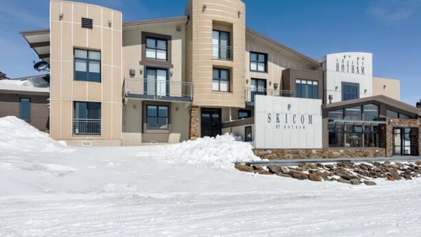 A modern building with a sign reading "SKICOM by Rotham."